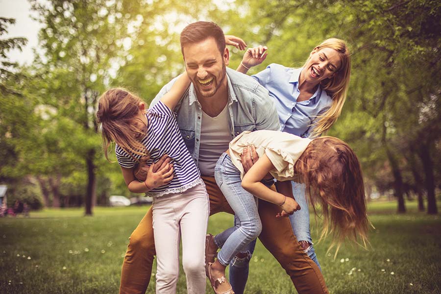 Personal Insurance - Family Having Fun Playing Outside In The Backyard On Warm Day